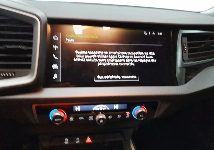 Vue rapprochée de la console centrale de l'Audi A1 Sportback 2023 avec écran tactile et commandes de climatisation bicolores.