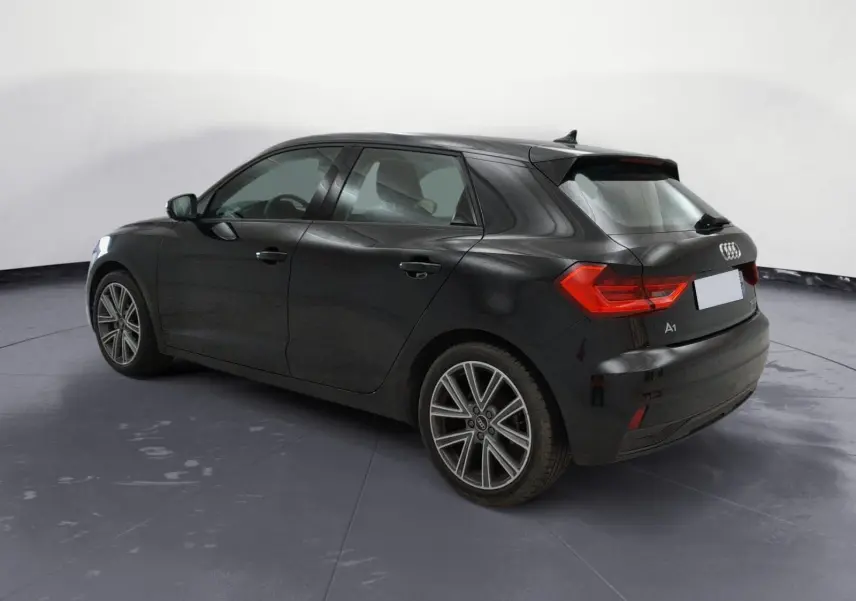 Audi A1 Sportback noir vue 3/4 arrière côté gauche, avec feux arrière LED et jantes alliage distinctives.