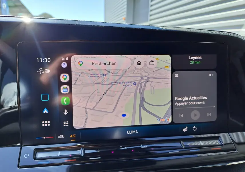 Vue rapprochée de l'écran tactile central du Volkswagen Caddy Cargo Maxi blanc, affichant la navigation et les commandes climatiques.