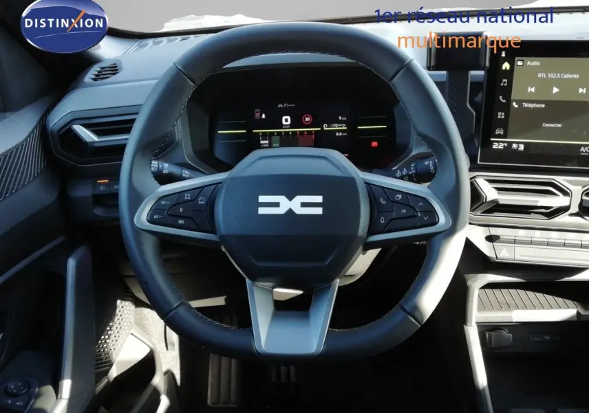 Vue rapprochée du volant multifonction et du tableau de bord numérique d’un Dacia Duster 2026, intérieur gris noir.