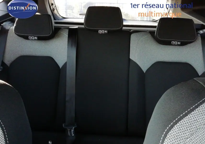 Vue intérieure arrière du Dacia Duster 2026, sièges en tissu gris et noir avec appuie-têtes et ceinture de sécurité visible.