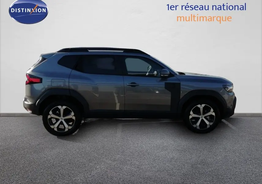 Profil droit du Dacia Duster TCE MHEV 140ch Journey gris schiste métal, avec jantes bi-ton et protections noires.