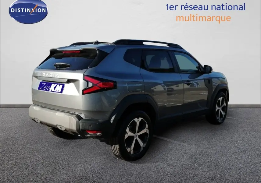 Vue 3/4 arrière droite du Dacia Duster TCE MHEV 140ch Journey gris schiste métal avec jantes bi-ton et feux LED distinctifs.