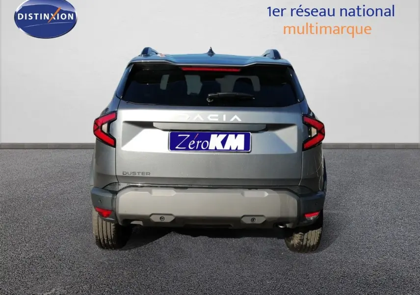 Vue arrière d'un Dacia Duster gris schiste métal 2026 avec feux LED et logo Dacia bien visibles.