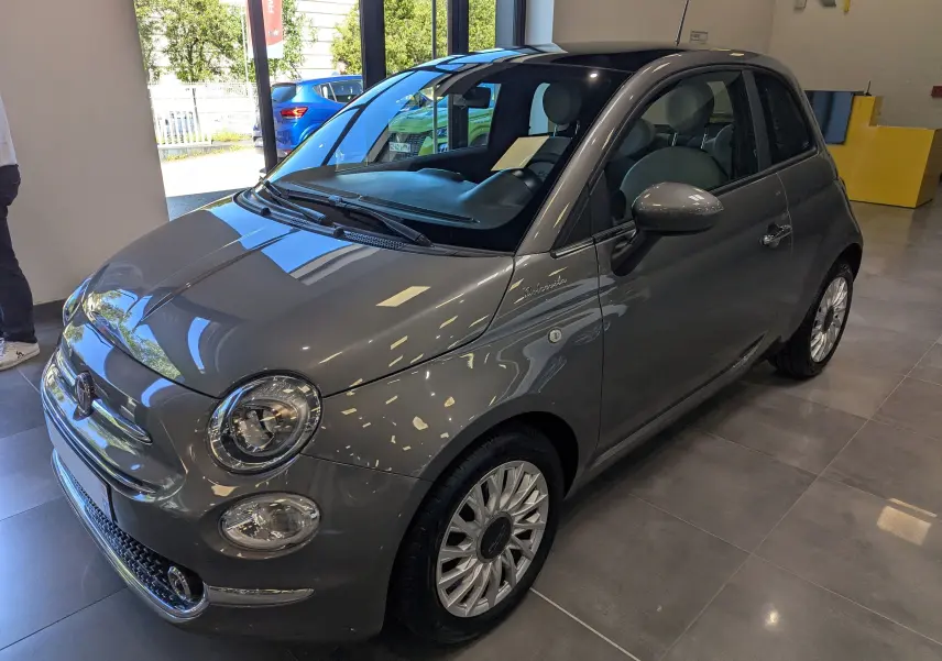 Fiat 500 Electroclash Grey vue 3/4 avant droit en showroom, avec jantes alliage et finition DolceVita visible sur l'aile.