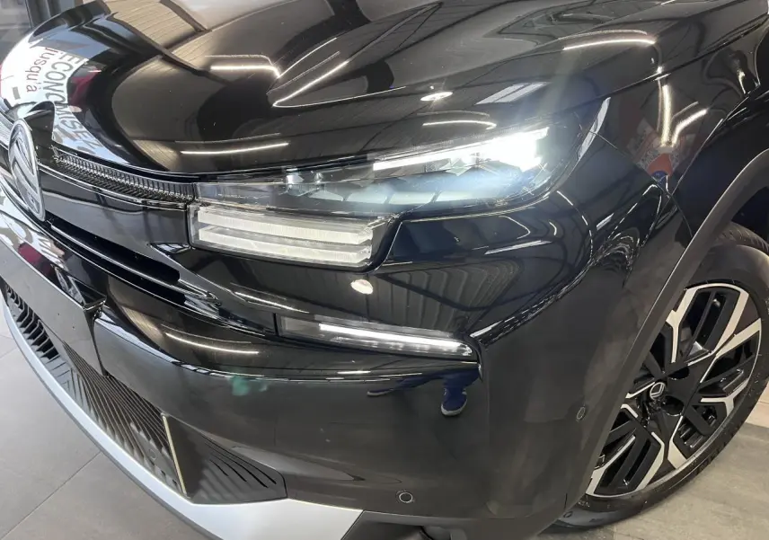 Gros plan sur l'avant droit noir métallisé du Citroën C4 2025 avec phares LED et jante alliage 18 pouces.