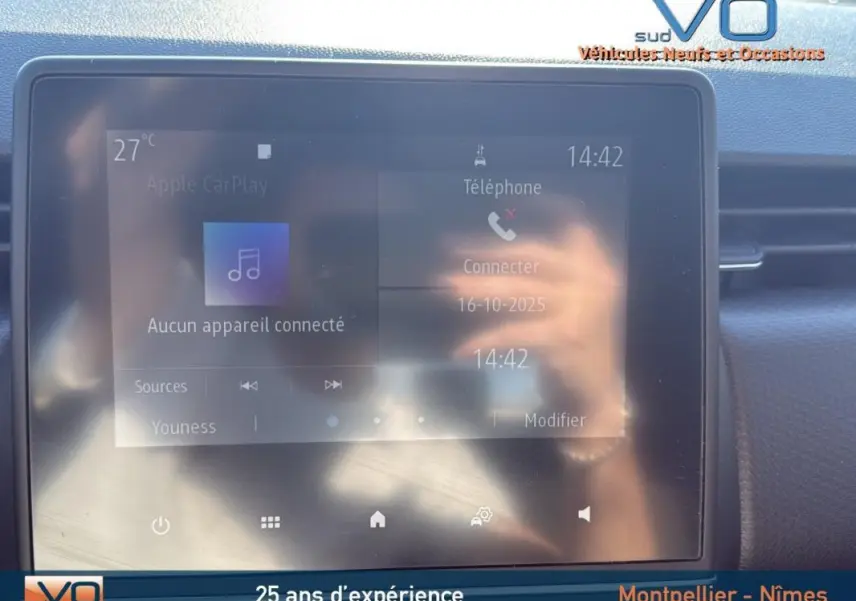 Écran tactile central de la Renault Clio gris 2022 affichant la connectivité téléphone et musique, intérieur avant.