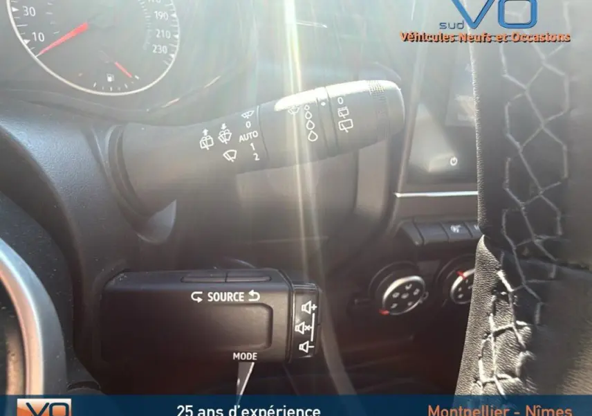 Gros plan sur la commande des essuie-glaces et la climatisation manuelle dans le tableau de bord d'une Renault Clio gris 2022.