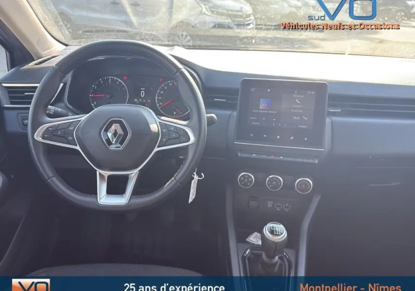 Intérieur de la Renault Clio V TCe 90 Equilibre 2022, vue frontale du tableau de bord avec volant et console centrale noire.