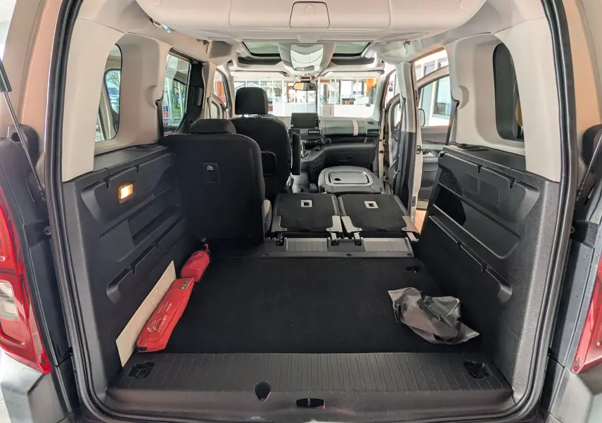 Vue arrière ouverte du Citroën Berlingo beige 2019, montrant l'espace de chargement avec sièges arrière rabattus.