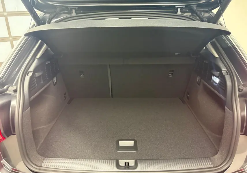 Coffre ouvert d’un Audi Q2 35 TFSI S Line gris Daytona, vue arrière montrant l’espace de chargement vide et la tablette cache-bagages.