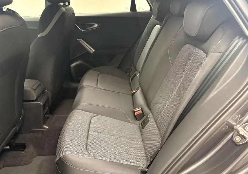 Vue latérale droite de la banquette arrière en tissu gris de l'Audi Q2 35 TFSI S Line, intérieur sobre et moderne.