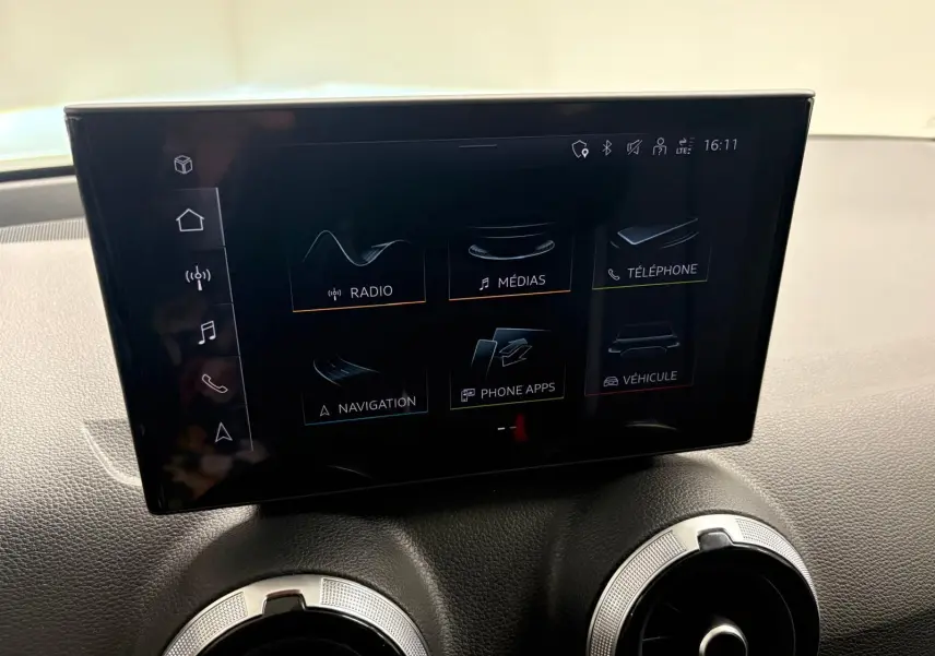 Écran tactile central de l’Audi Q2 35 TFSI S Line 2026 avec interface multimédia affichant radio, médias et navigation.