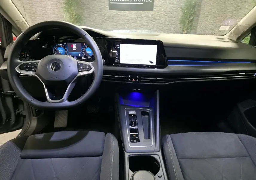 Intérieur avant de la Volkswagen Golf 1.4 eHybrid 2020, tableau de bord moderne avec éclairage bleu et volant multifonction.