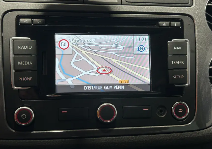 Écran GPS du tableau de bord du Volkswagen Tiguan 2015 affichant une carte et les commandes autour.