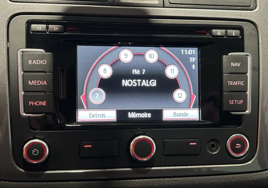 Écran central multimédia de Volkswagen Tiguan 2015 affichant la radio FM sur fond noir avec boutons autour.