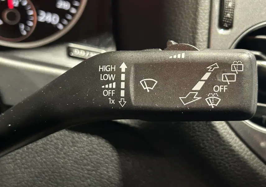 Gros plan sur la commande d'essuie-glace du Volkswagen Tiguan 2015, avec tableau de bord en arrière-plan.