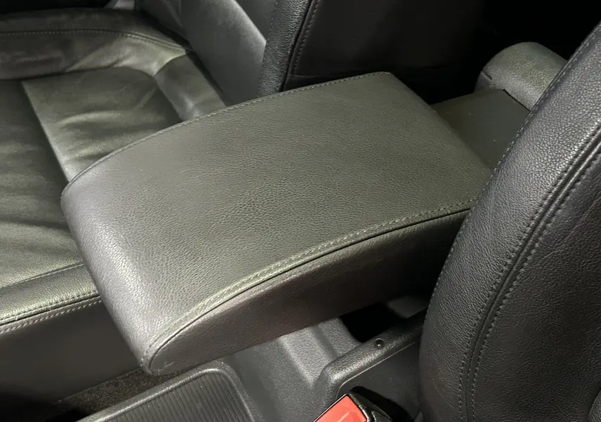 Gros plan sur l'accoudoir central en cuir noir entre les sièges avant du Volkswagen Tiguan 2015.