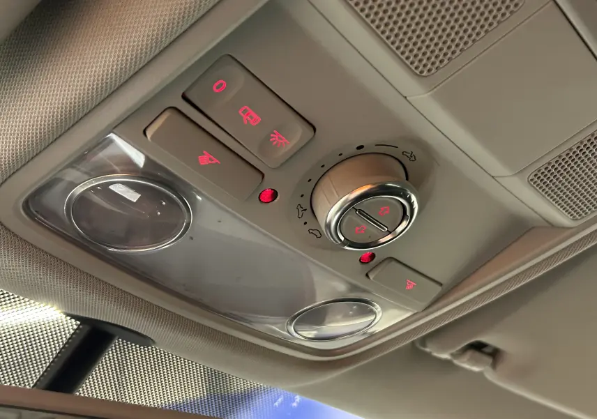 Vue en gros plan du plafonnier avec commandes d’éclairage et de toit ouvrant dans un Volkswagen Tiguan noir métal 2015.