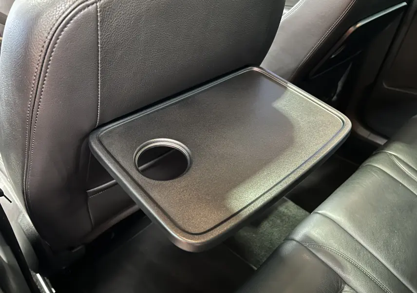 Tablette rabattable avec porte-gobelet sur le dossier avant côté droit, intérieur cuir noir du Volkswagen Tiguan 2015.