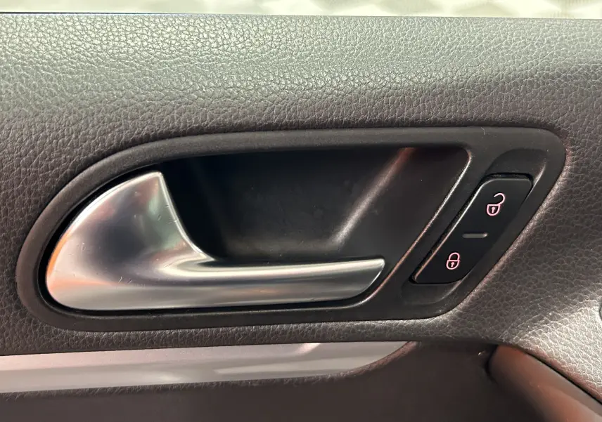 Poignée intérieure de porte côté gauche en métal brossé sur Volkswagen Tiguan noir métal 2015.