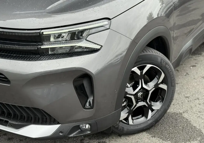 Gros plan sur l'avant droit gris Platinium du Citroën C5 Aircross 2025 avec phares LED et jante alliage bi-ton.