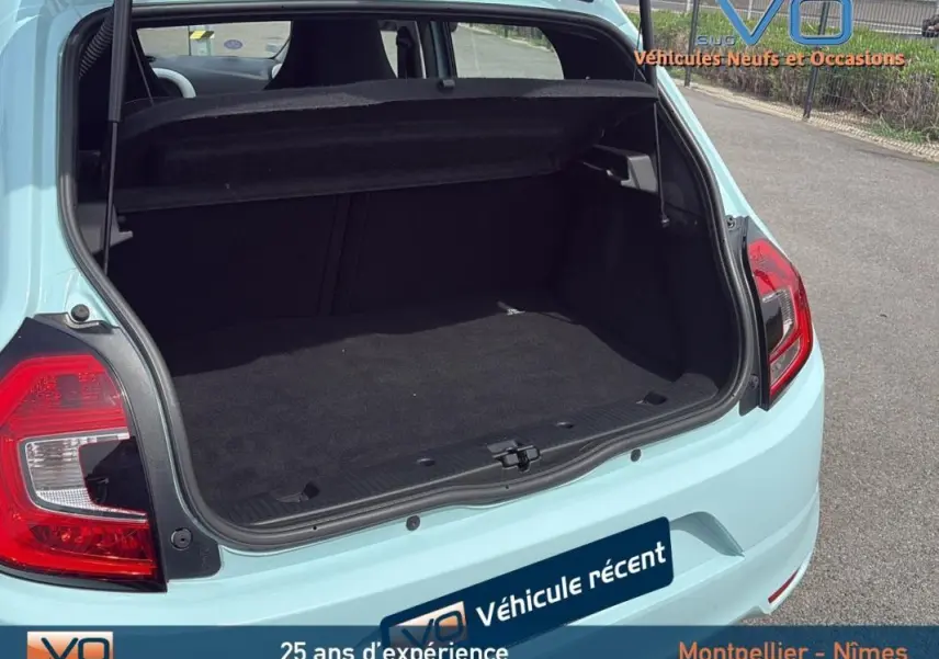 Coffre ouvert vu de l'arrière d'une Renault Twingo III bleu clair, montrant l'espace de chargement vide.
