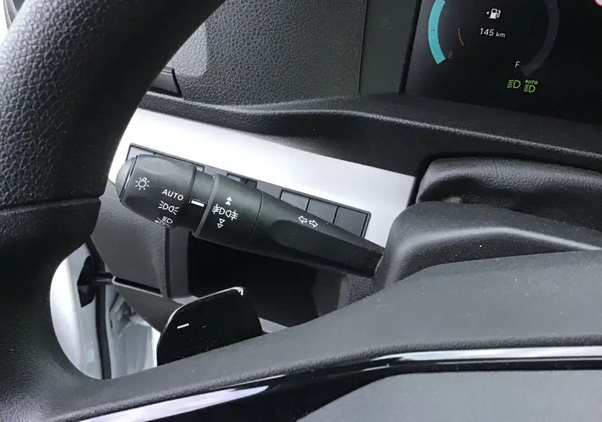 Détail du commodo d'éclairage à gauche du volant dans l'habitacle du Fiat Scudo Fourgon blanc 2024.