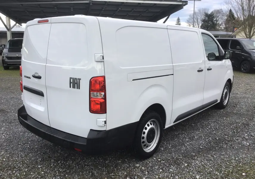 Fiat Scudo Fourgon blanc vu en 3/4 arrière droit, avec plaque de protection tôlée et garde au sol rehaussée.