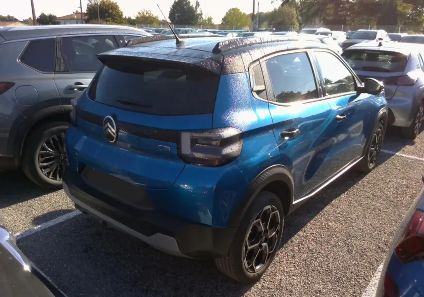 Vue 3/4 arrière droite d'une Citroën C3 2025 Bright Blue avec toit noir Perla et jantes alliage noires.
