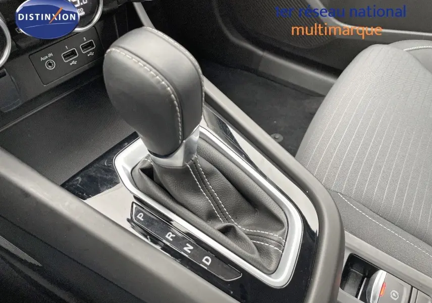 Le levier de vitesses automatique noir de la Renault Arkana 1.3 TCE 140 Evolution, avec coutures blanches, vue rapprochée intérieure.