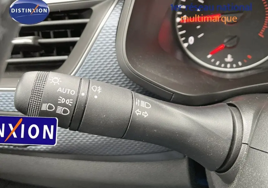 Gros plan sur la manette de commande des phares et clignotants dans l'habitacle d'une Renault Arkana noire 2023.