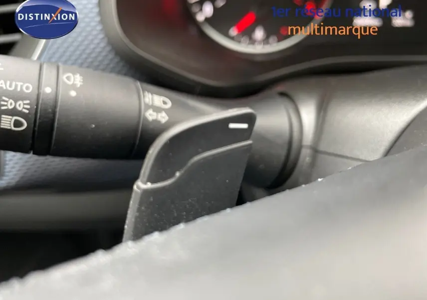 Détail de la commande au volant noir et levier de clignotant dans l’habitacle d’une Renault Arkana noire 2023.