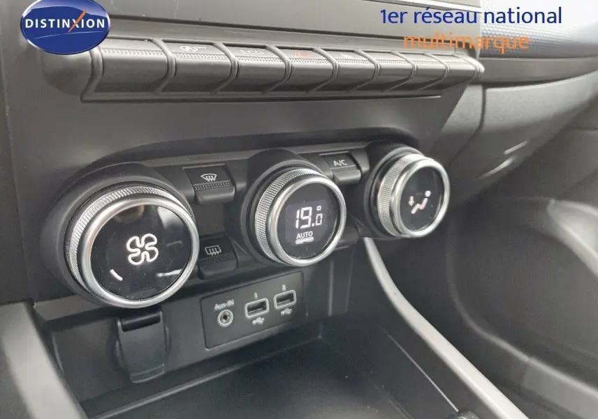 Gros plan sur la console centrale du Renault Arkana noir 2023, montrant les commandes de climatisation et ports USB.