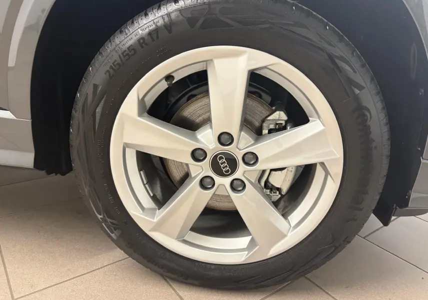 Gros plan sur la roue avant gauche de l'Audi Q2 35 TFSI S Line 2026 en gris Daytona avec jante argentée cinq branches.
