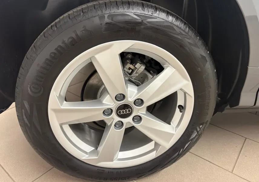 Gros plan sur la roue avant droite de l'Audi Q2 35 TFSI S Line 2026 en gris Daytona, avec jante alliage cinq branches.