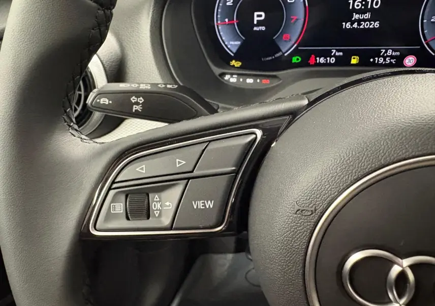Gros plan sur les commandes gauche du volant et le tableau de bord numérique d’un Audi Q2 35 TFSI 2026.