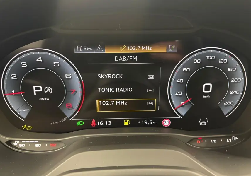 Tableau de bord numérique de l'Audi Q2 35 TFSI S Line 2026 affichant la radio DAB/FM et compteurs à zéro.