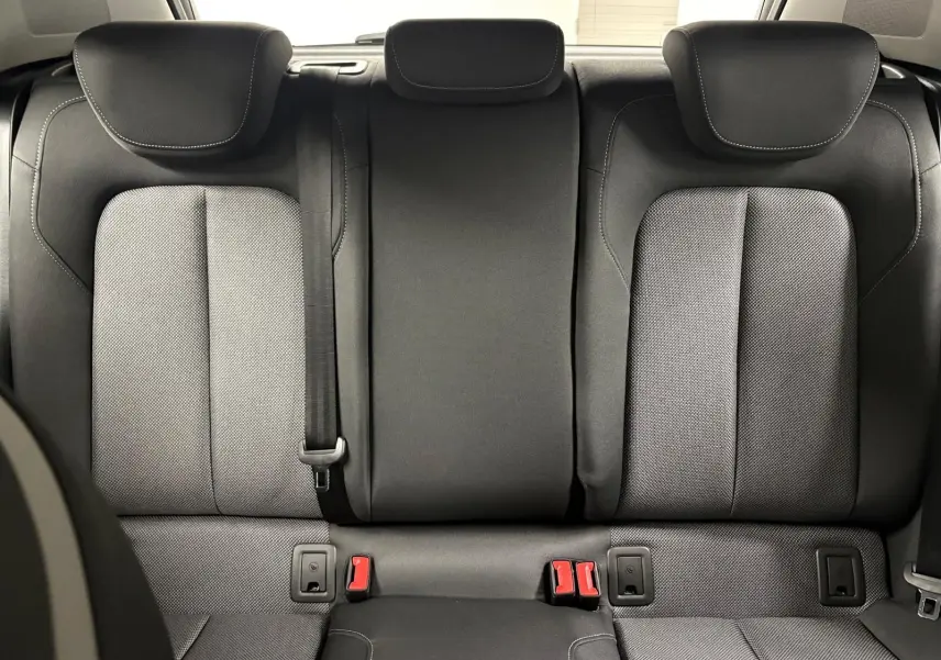 Vue arrière intérieure des sièges arrière noirs de l'Audi Q2 35 TFSI S Line 2026, avec appuie-têtes et ceintures visibles.