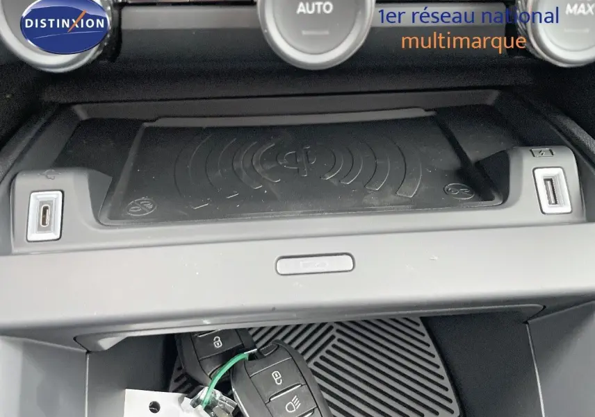 Gros plan sur la console centrale de la Citroën C4 blanche 2024, montrant la recharge sans fil et deux ports USB.