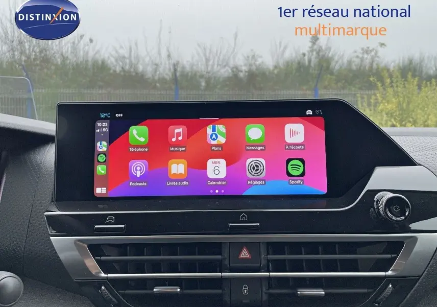 Écran tactile central allumé avec interface Apple CarPlay dans le tableau de bord d'une Citroën C4 blanche.