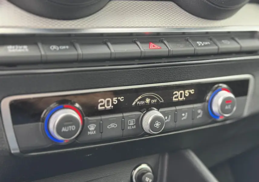 Détail de la console centrale avec commandes de climatisation automatique bi-zone de l'Audi Q2 2022 noire.