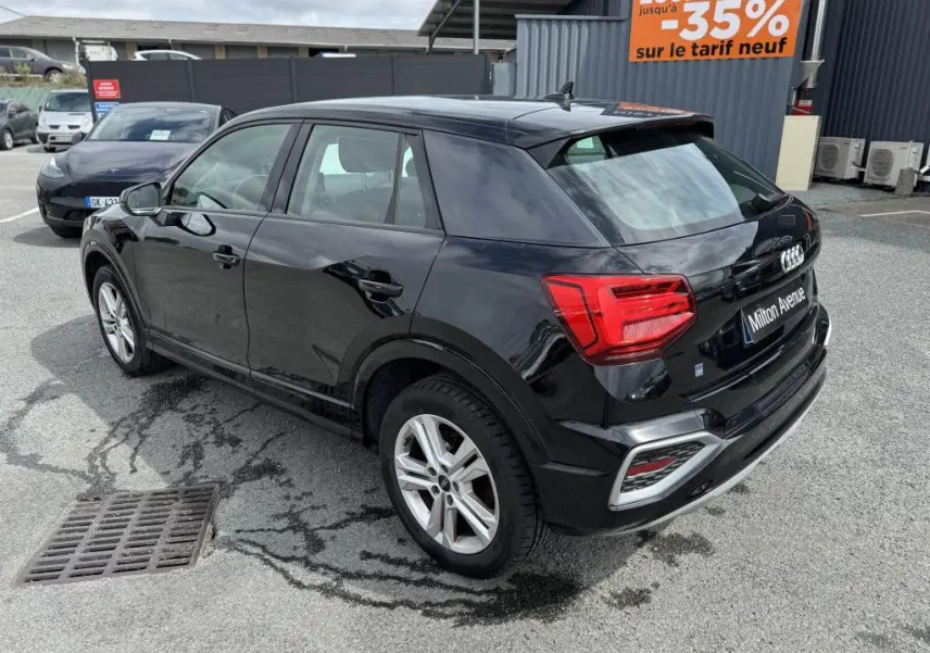Audi Q2 noire vue en 3/4 arrière droit, avec feux LED et jantes aluminium 5 branches doubles.