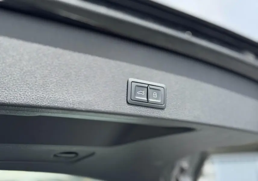 Boutons de fermeture et verrouillage du coffre sur le hayon intérieur d'un Audi Q2 noir 2022 Design.