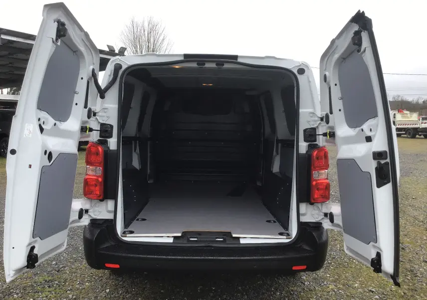 Vue arrière du FIAT Scudo Fourgon blanc 2024 avec portes battantes ouvertes, montrant l'espace de chargement vide et protégé.