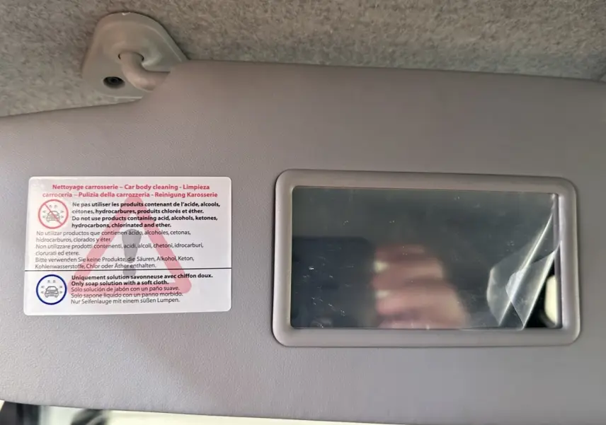 Image ne montrant pas le véhicule AIXAM AMBITION 0.5 CITY GTO, mais un miroir de pare-soleil intérieur avec consignes de nettoyage.