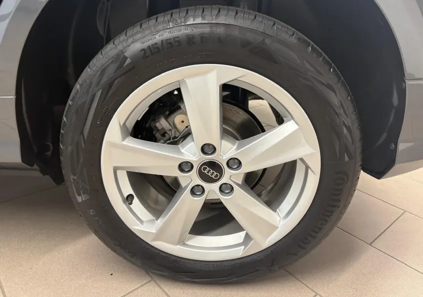 Gros plan sur la roue avant droite d’un Audi Q2 35 TFSI 150 S Line gris Daytona avec jante alliage cinq branches.