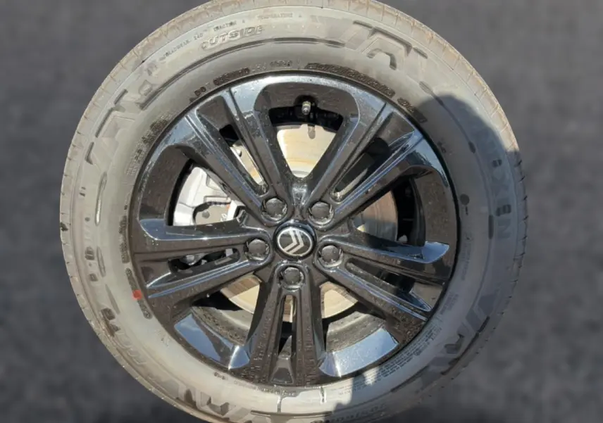 Gros plan sur la jante alu noire du Citroën Berlingo Steel Grey avec logo Citroën au centre.