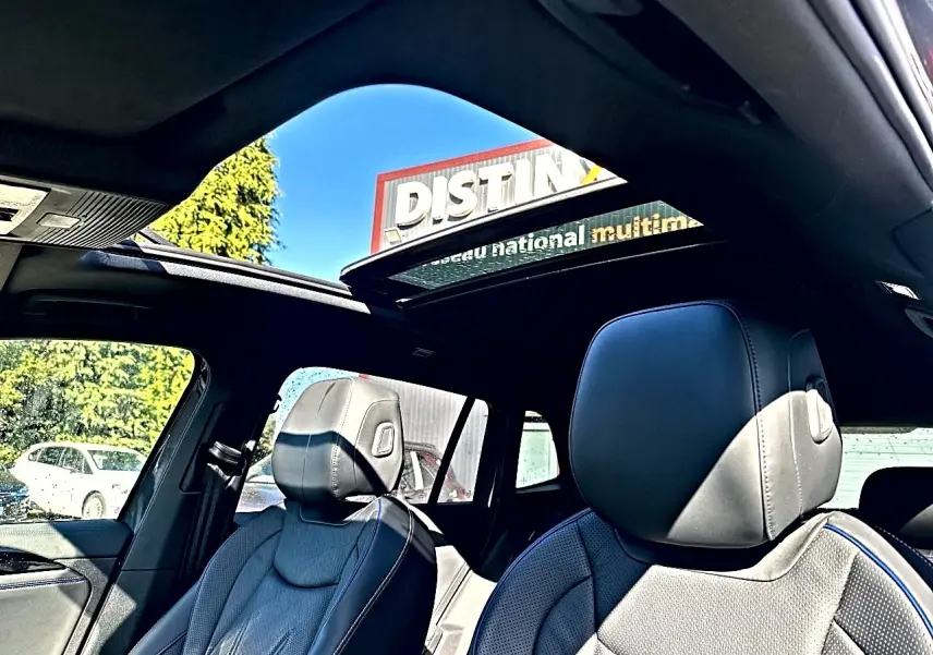 Vue intérieure du Volkswagen Tiguan gris dauphin 2024, sièges cuir noir R-Line et toit ouvrant panoramique en verre.