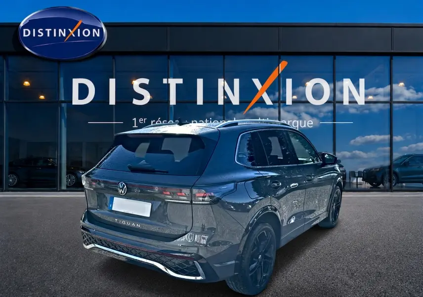 Volkswagen Tiguan 2.0 TDI gris dauphin en 3/4 arrière droit, avec jantes noires et feux LED distinctifs.